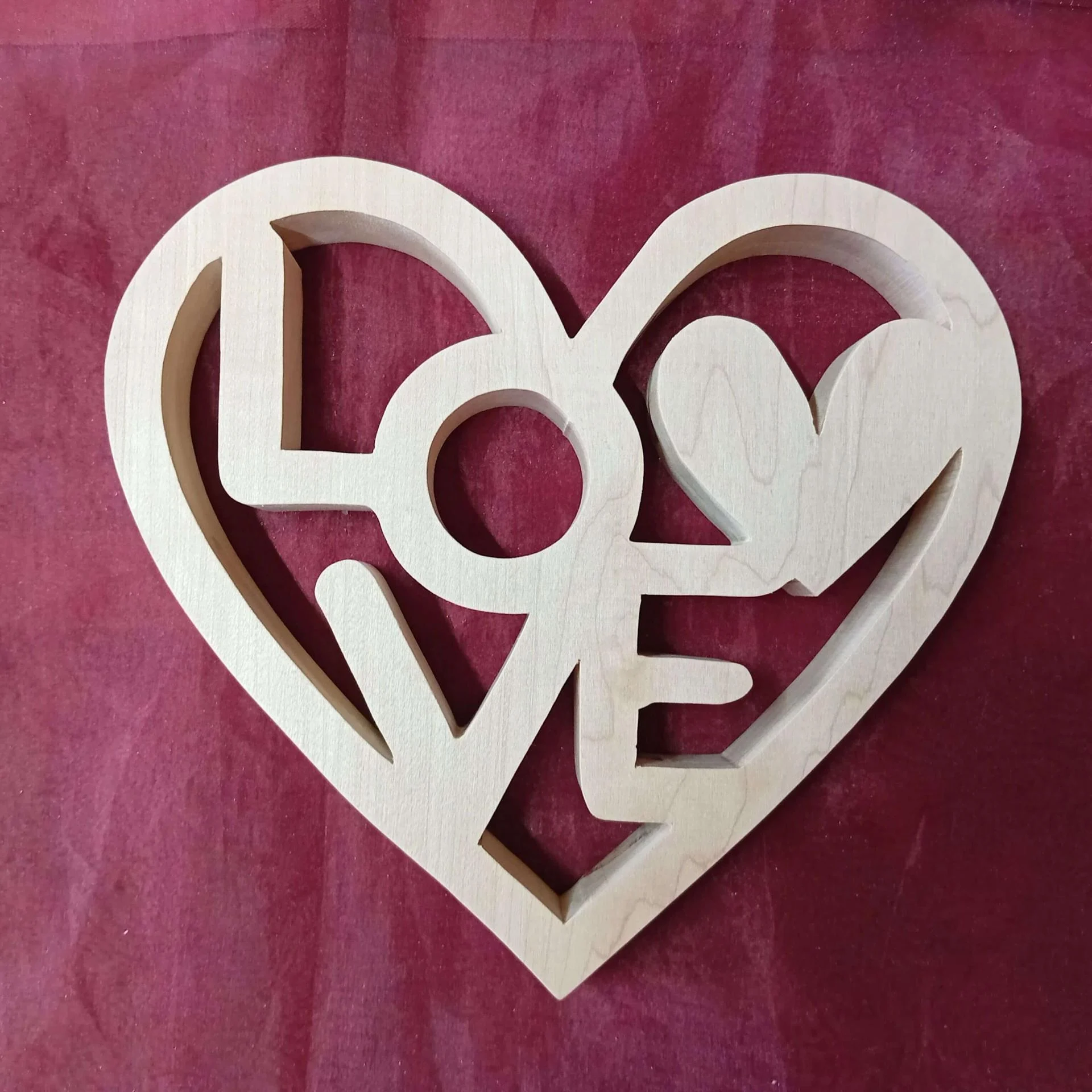 Décoration en bois, découpée à la scie à chantourner, représentant un coeur avec l'inscription LOVE.